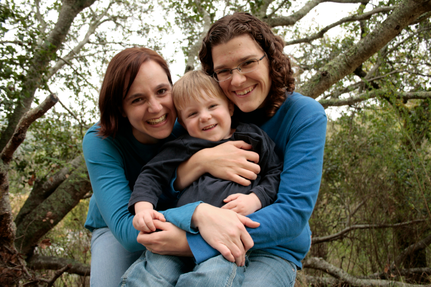 Portrait of lesbian family walking on wooden bridge by victor torres