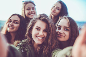 Group of Smiling Girls Taking a Selfie Outdoors at Sunset